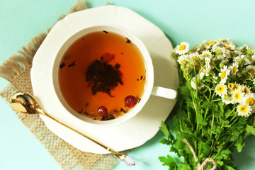 Cup of fresh herbal tea on table