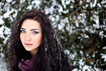 Dark-haired woman in winter snowy forest