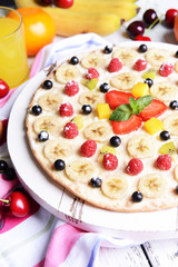 Sweet pizza with fruits on table close-up