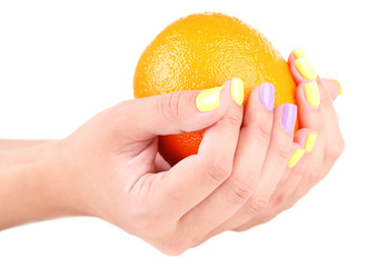 Female hand with stylish colorful nails holding fresh orange,