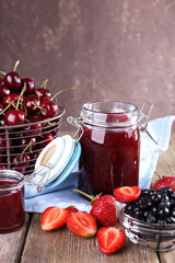 Berries jam in glass jar on table, close-up
