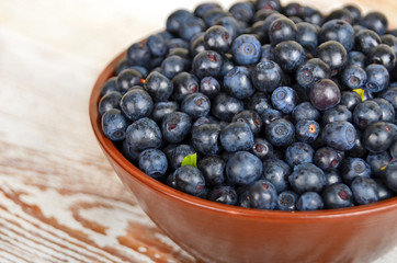 Blueberry in bowl on vintage wooden background