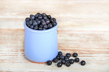 Fototapeta na wymiar Blueberry in cup on vintage wooden background
