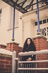 Woman near brick wall and entrance door