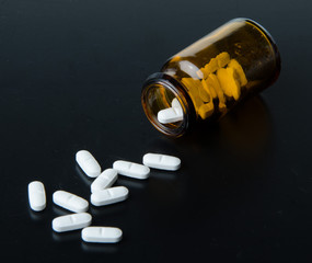 Pills spilling out of pill bottle