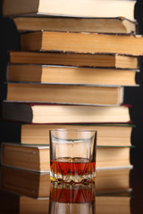 Glass of whiskey and books