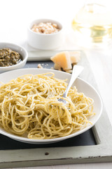 spaghetti with pesto and cheese on a plate, selective focus