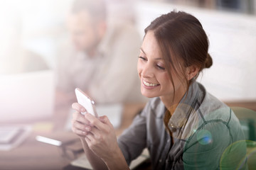 Young woman in training class sending text message