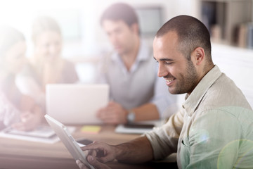 Fototapeta premium Young man in office working on digital tablet