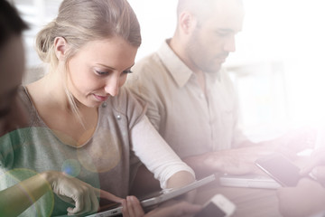 Group of business people using electronic devices at work