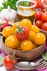 yellow and red cherry tomatoes in wooden bowl, olive oil