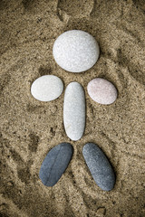 Fototapeta na wymiar Stones in human form closeup in the sand