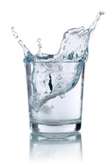 Eiswürfel fällt in ein Glas mit Wasser