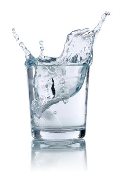 Eisw&uuml;rfel f&auml;llt in ein Glas mit Wasser