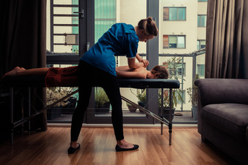 Massage therapist treating patient at home