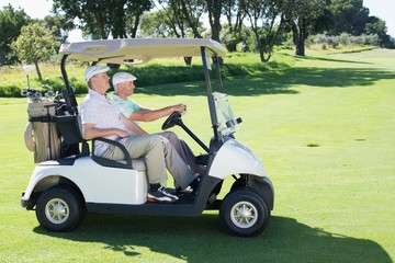 Golfing friends driving in their golf buggy