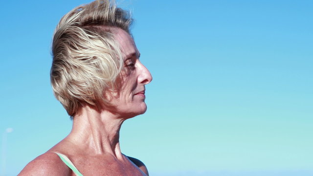 Fit senior woman pausing on her run