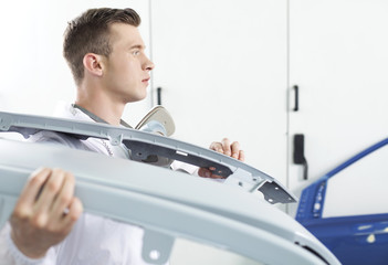 Obraz premium young man holding car door.