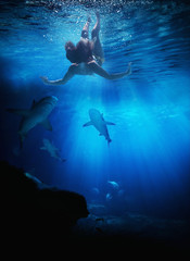 Young woman swimming with skarks i