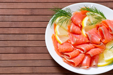 Sliced salted salmon served with lemon