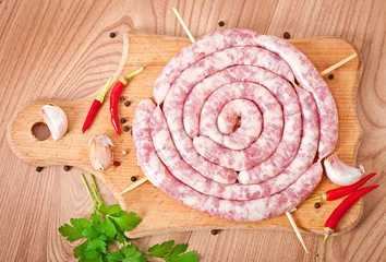 Gardinen Fresh raw sausage on wooden background © timolina