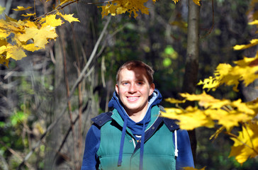 The cheerful guy in the autumn wood.