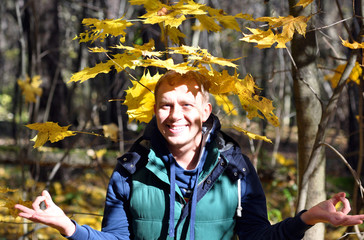 The cheerful guy in the autumn wood.