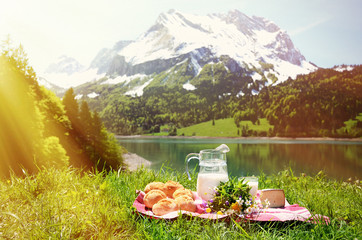 Milk, cheese and bread served at a picnic on Alpine meadow, Swit