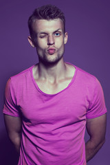 Emotive portrait of muscular young handsome man gives a kiss in