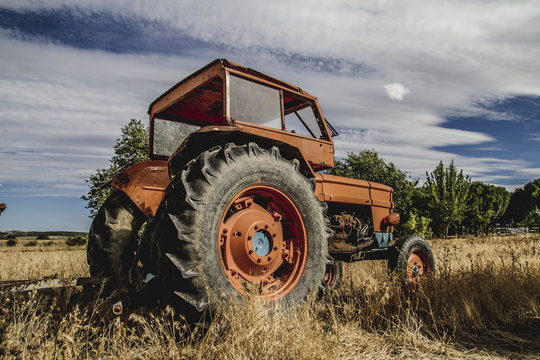 farming, old agricultural tractor abandoned in a farm field