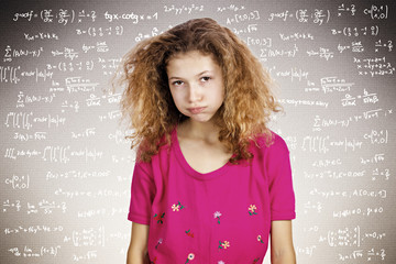 Stressed student standing in front of blackboard with formulas