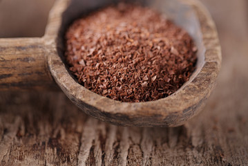 fine grated chocolate in old wooden spoon