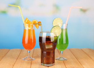 Tasty cocktails on swimming pool background