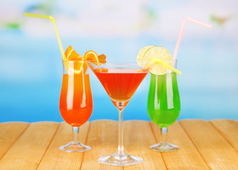 Tasty cocktails on swimming pool background