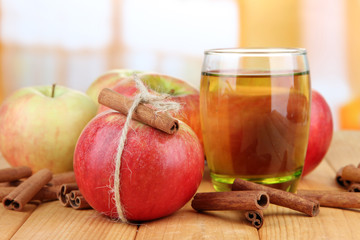 Ripe apples with with cinnamon sticks and glass of  apple drink