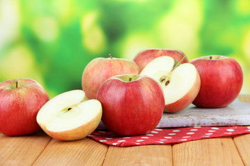 Ripe apples on  wooden table, on bright background