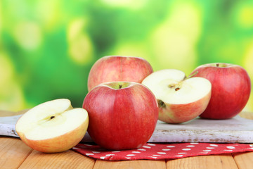 Ripe apples on  wooden table, on bright background