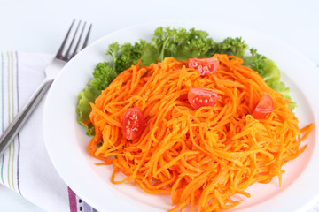 Carrot salad on plate on napkin isolated on white