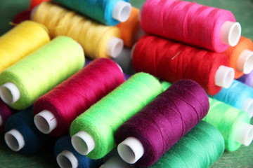 Multicolor sewing threads on wooden background