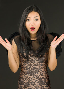 Asian young woman dressed up as a black angel with shrugging
