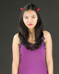 Devil side of a young Asian woman looking sad