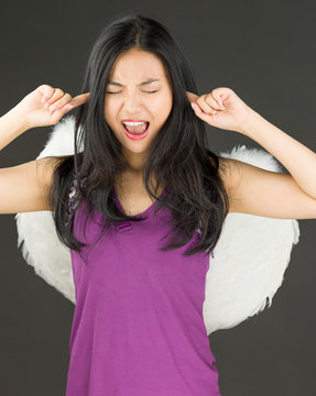 Angel side of a young Asian woman shouting in frustration with