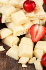 Broken white chocolate bar with fresh strawberries,