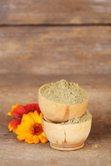 Dry henna powder in bowls on wooden table