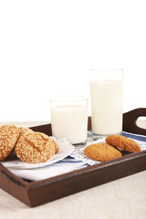 Milk and cookies on wooden tray isolated on white