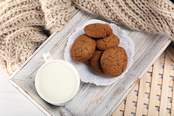Milk and cookies on tray on table