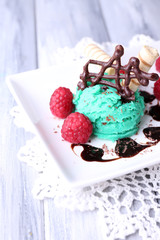 Tasty ice cream with chocolate decorations and sauce plate,