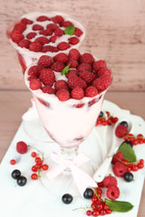 Tasty raspberry dessert with berries on pink wooden background