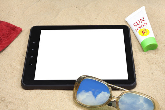 Summer background with digital tablet on the sand.