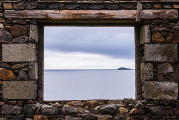Sea view from a stone window of an old ruin near the ocean